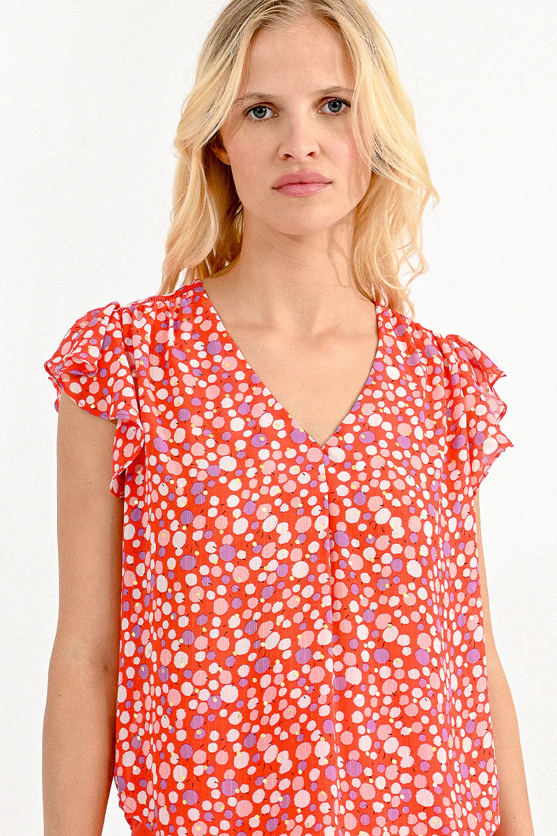 V-neck top with ruffled shoulders, a trendy urban look with a colorful polka dot pattern