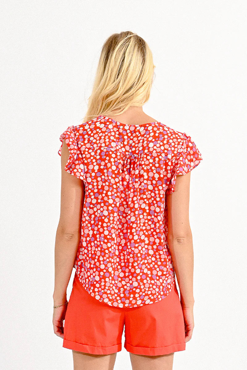 V-neck top with ruffled shoulders, a trendy urban look with a colorful polka dot pattern